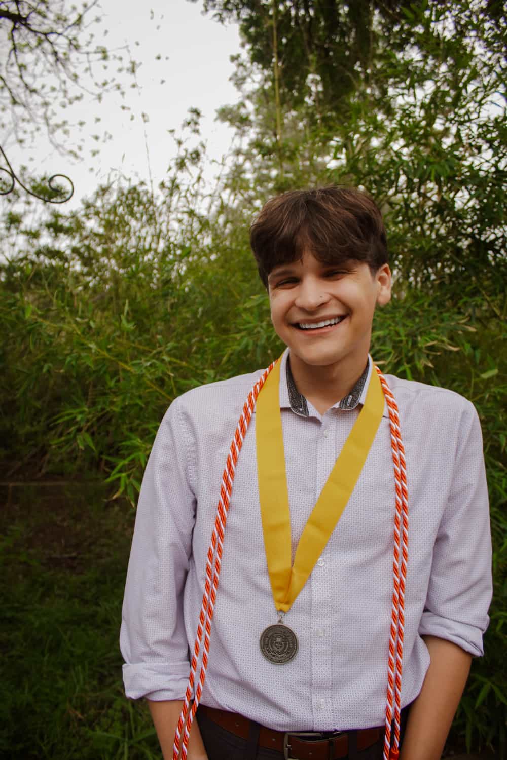 Diego smiling to camera in front of tree.
